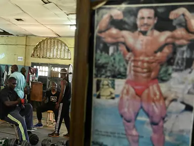 Sejumlah binaragawan mengangkat beban saat berolahraga di gym Kaloleni, di Nairobi, Kenya (9/1). (AFP Photo/Simon Maina)