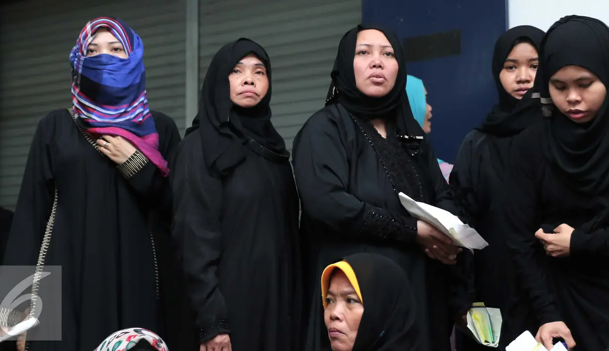 Sejumlah Tenaga Kerja Indonesia (TKI) menunggu bus di Bandara Soekarno Hatta,Tangerang, Rabu (11/11). Sebanyak 450 WNI overstayers dan TKI undocumented dari Jeddah, Arab Saudi dipulangkan pemerintah Indonesia. (Liputan6.com/Angga Yuniar)