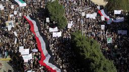 Bendera Yaman dibentangkan saat demonstrasi mengecam pembakaran Al-Quran oleh seorang politisi Swedia di ibu kota Sanaa pada 23 Januari 2023. Ribuan warga Yaman di ibu kota Sanaa turut berunjuk rasa. (AFP/Mohammed Huwais)
