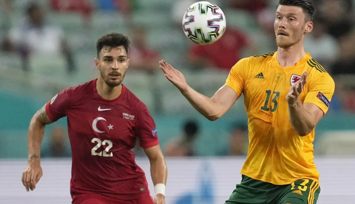 Penyerang Wales, Kieffer Moore mengontrol bola dari kawalan pemain Turki, Kaan Ayhan pada pertandingan grup A Euro 2020 di Stadion Olimpiade Baku di Baku, Rabu (16/6/2021). Hasil ini memperbesar kans Wales melaju ke babak gugur. Mereka selanjutnya menghadapi Italia. (AP Photo/Darko Vojinovic, Pool)