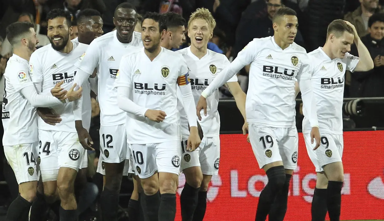 Para pemain Valencia merayakan gol yang dicetak oleh Ezequiel Garay ke gawang Real Madrid pada laga La Liga 2019 di Stadion Mestalla, Rabu (3/4). Valencia menang 2-1 atas Real Madrid. (AP/Alberto Saiz)