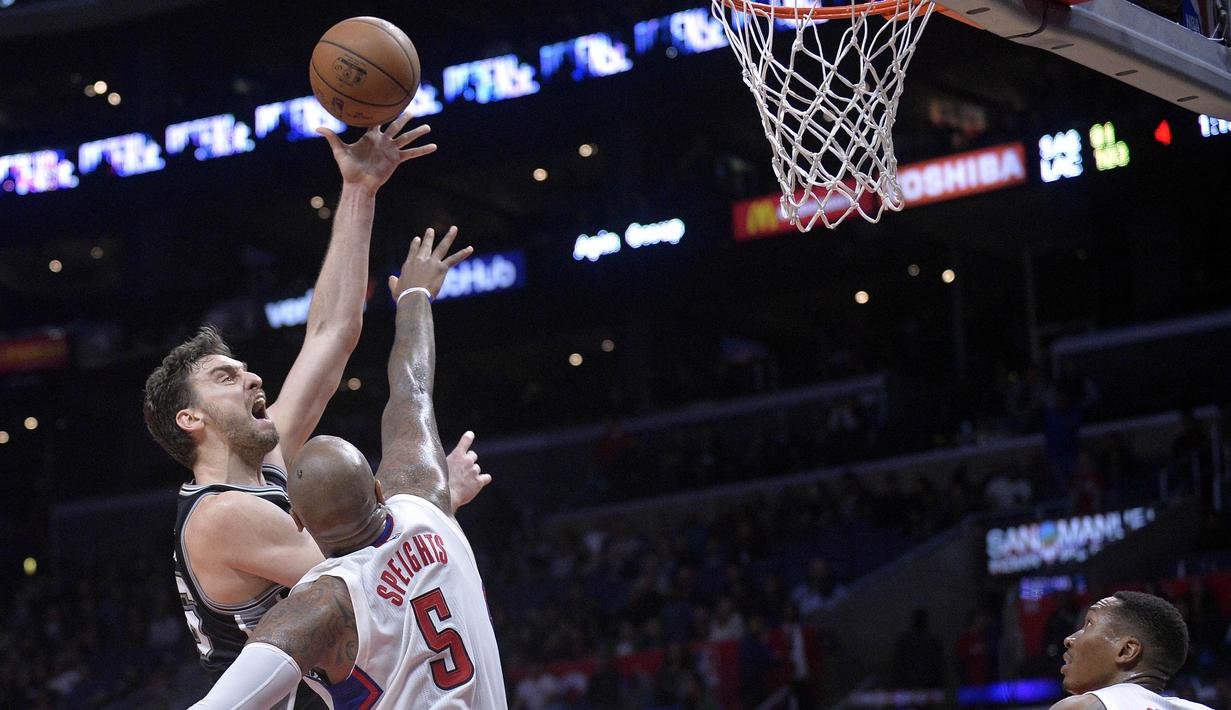 Ekspresi pemain Spurs, Pau Gasol (kiri) saat melakukan tembakan melewati hadangan pemain L. A. Clippers, Marreese Speights pada laga NBA basketball game di Staples Center, (22/12/2016). Clippers menang 106-101. (Reuters/Gary A. Vasquez-USA TODAY Sports)