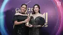 Penyanyi Raisa dan Isyana Sarasvati memenggang piala usai meraih penghargaan dalam Anugerah Musik Indonesia (AMI) Awards 2017 di Teater Garuda TMII, Jakarta, Kamis (16/11). (Liputan6.com/Herman Zakharia)