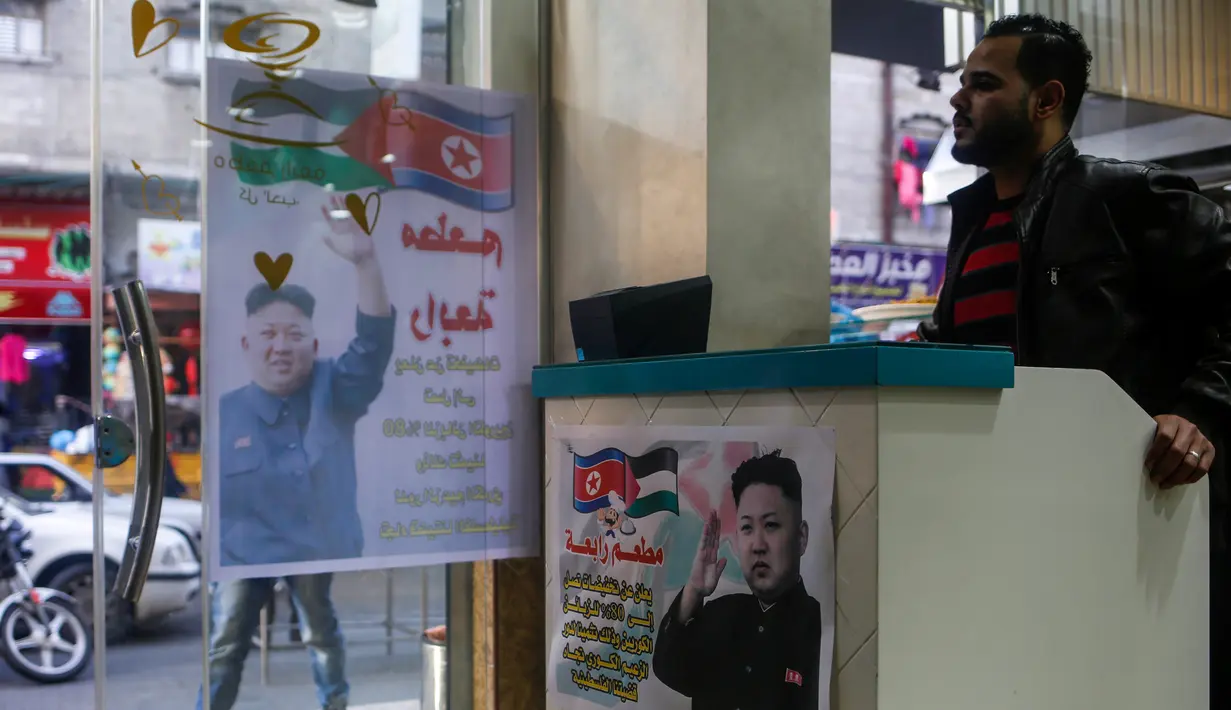 Seorang kasir menunggu di pintu masuk restoran Rabaa di kamp pengungsi Jabalia, Gaza, Minggu (17/12). Restoran Rabaa menawarkan potongan harga besar untuk pengunjung asal Korea Utara meskipun tidak ada orang Korea Utara di Gaza. (MOHAMMED ABED/AFP)