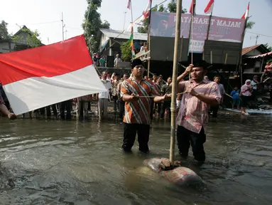 Sejumlah warga mengikuti upacara HUT RI ke 71 di Sungai Winongo, Yogyakarta, Rabu (17/8). Upacara berlangsung khidmat meskipun dilaksanakan di tengah aliran  sungai. (Liputan6.com/Boy Harjanto)