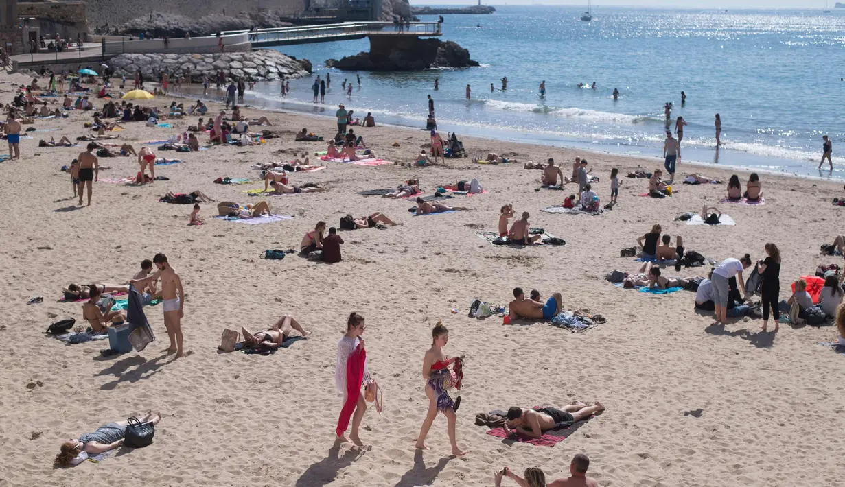 Orang-orang berjemur dan berenang di pantai Catalans (Plage des Catalans) di Marseille, Prancis Selatan, (17/4). Pantai Catalans di Marseille adalah pantai paling populer dan paling dekat dengan Vieux-Port (Old Harbour). (AFP Photo/Bertrand Langlois)
