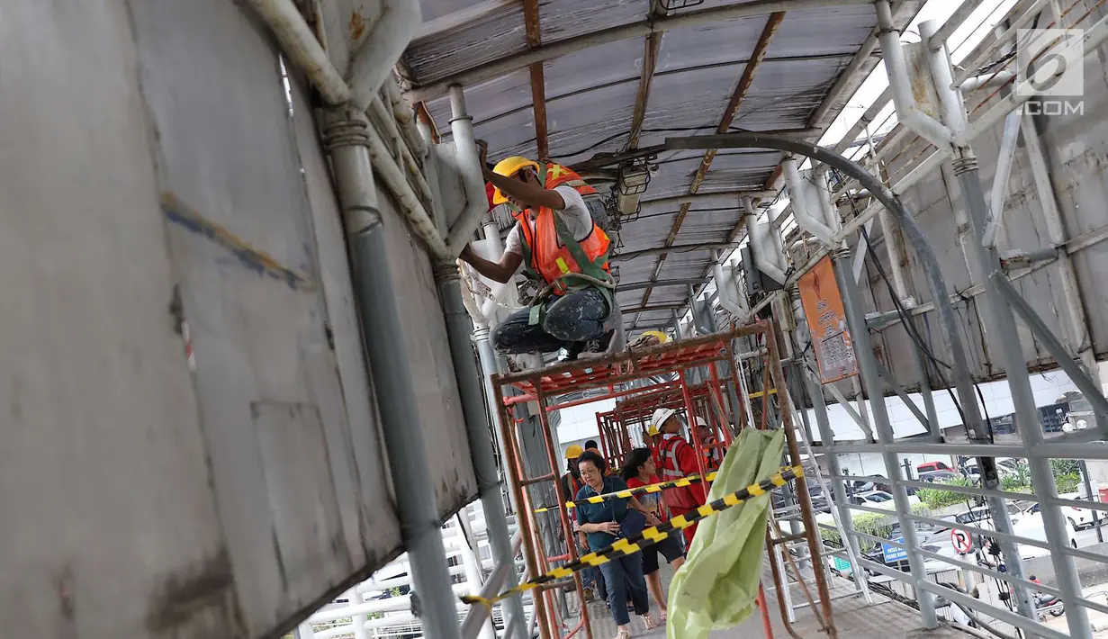 Pekerja mengecat jembatan penyeberangan orang di kawasan Senayan, Jakarta, Jumat (6/7). Pengecatan tersebut merupakan bagian dari proyek revitalisasi JPO guna meningkatnya kenyamanan pejalan kaki. (Liputan6.com/Immanuel Antonius)