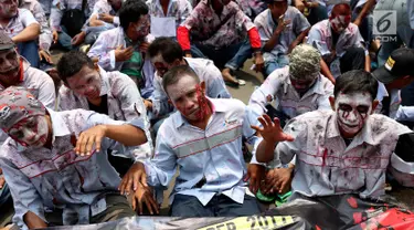 Massa buruh awak mobil tangki (AMT) berdandan seperti zombi melakukan aksi di depan gedung Pertamina, Jakarta, Senin (23/10). (Liputan6.com/Angga Yuniar)