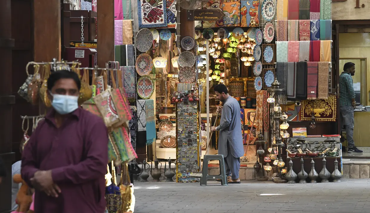 Seorang pria duduk di depan toko suvenir di Deira Souk di kota Emirat Dubai (30/9/2020). (AFP/Karim Sahib)