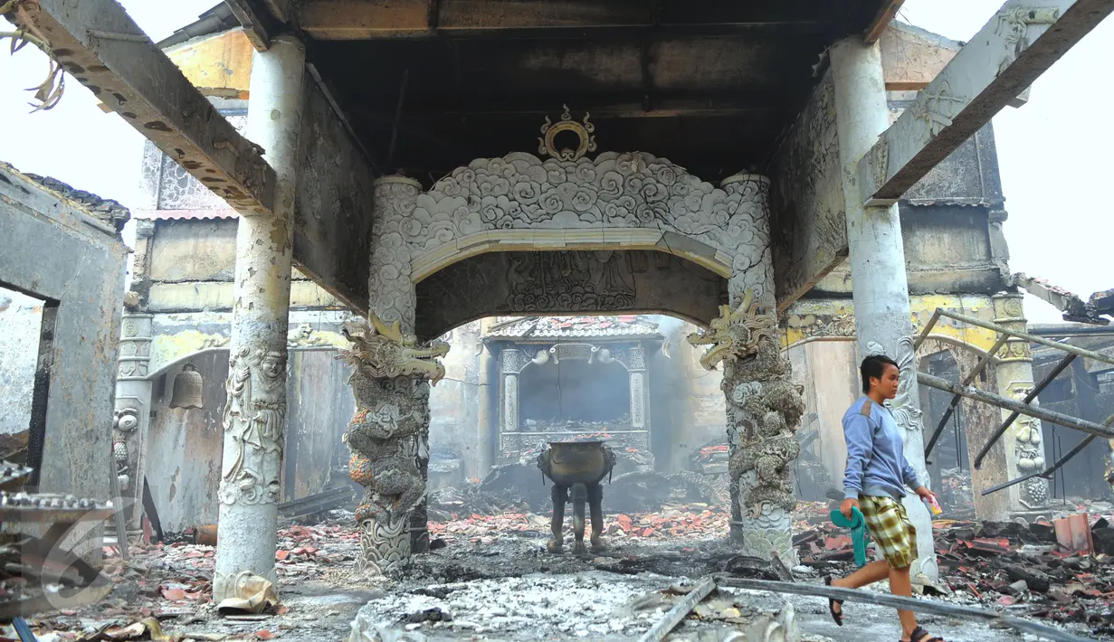 Warga saat melintas di Vihara Butong yang rusak akibat kebakaran, Tangerang, Banten, Jumat (19/2). Kebakaran untuk saat ini, diduga dari lilin yang berada di Vihara yang menyambet saluran listrik. (Liputan6.com/Faisal R Syam)