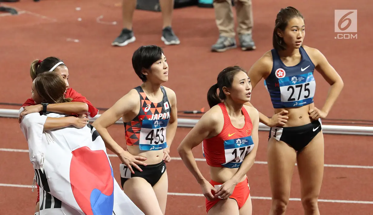 Pelari Indonesia, Nova Emilia berpelukan dengan pelari Korea Selatan Jung Hyelim usai final atletik nomor lari halang rintang 100 meter putri di Stadion Utama GBK, Jakarta (26/8). Nova Emilia berhasil meraih medali perak.  (Liputan6.com/Fery Pradolo)