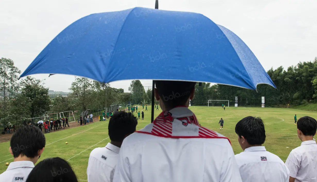 Hujan tak menghalangi pelajar Sekolah Pelita Harapan untuk menonton latihan Timnas Indonesia di Lapangan SPH Sentul, Jawa Barat, Kamis (1/12/2016). Timnas Indonesia akan melawan Vietnam pada Sabtu (3/12) esok. (Bola.com/Vitalis Yogi Trisna)