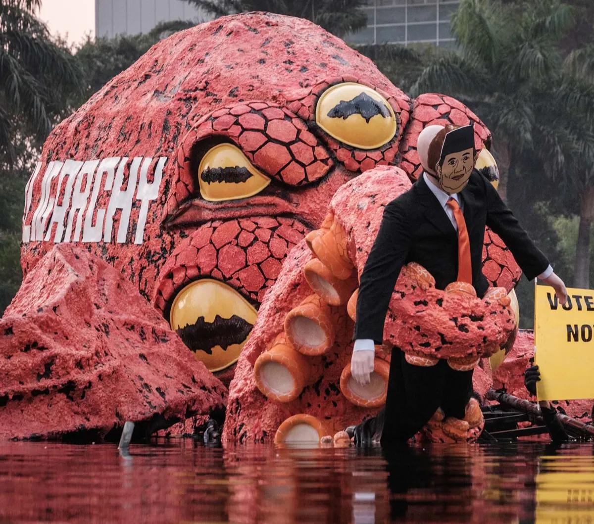 Aktivis Greenpeace Indonesia menggelar aksi untuk menyerukan #PemiluTanpaOligarki di Bundaran HI, Jakarta, Jumat (6/10/2023). Dalam aksinya, aktivis Greenpeace membawa monster gurita oligarki yang menduduki kolam Bundaran HI.