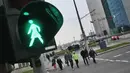 Orang-orang menyeberang jalan dengan lampu lalu lintas bergambar wanita di Vilnius, Lituania, Jumat (2/11). Hal itu untuk merayakan ulang tahun ke-100 wanita memperoleh pengakuan internasional dalam pemungutan suara di negara baltik. (Petras Malukas/AFP)