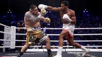 Petinju Anthony Joshua (kanan) bertanding melawan Andy Ruiz Jr (kiri) dalam kejuaraan tinju kelas berat dunia di Diriyah Arena, Riyadh, Arab Saudi, Minggu (8/12/2019). Anthony Joshua menang angka mutlak atas Andy Ruiz Jr. (Nick Potts / PA via AP)