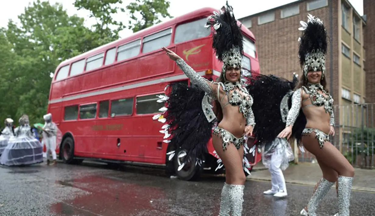 Aksi penari samba seksi saat tampil di dekat bus tingkat saat Karnaval Notting Hill di London,Inggris (31/8/2015). Karnaval Notting Hill diadakan untuk merayakan budaya Karibia yang sudah dikenal sejak 1960-an. (AFP PHOTO/LEON Neal)