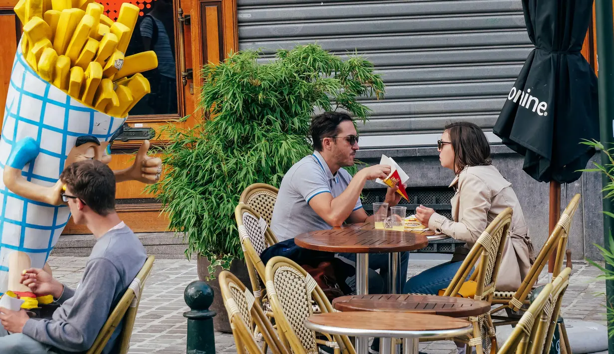 Sejumlah orang menyantap kentang goreng di sebuah kedai di Brussel, Belgia, 28 Juni 2020. Komisi Eropa memprediksi Ekonomi Eropa akan menghadapi resesi lebih dalam akibat langkah-langkah pengendalian COVID-19 yang berkepanjangan. (Xinhua/Zhang Cheng)