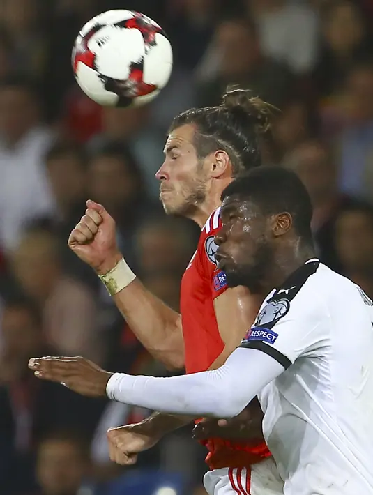 Duel pemain Wales, Gareth Bale dengan pemain Austria, Kevin Danso pada laga Group D kualifikasi Piala Dunia 2018 di Cardiff City Stadium, Cardiff, (2/8/2017). Wales menang 1-0.  (AFP/Geoff Caddick)