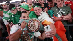 Fans McGregor asal Irlandia berfoto dengan replika sabuk WBC saat timbang badan di Las Vegas (25/8/2017). McGregor akan bertarung 26 agustus 2017. (AP/John Locher)