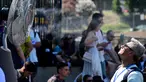 Sebuah kipas angin menyemprotkan air di sepanjang gerbang Colosseum, Roma untuk menyegarkan para turis pada tanggal 11 Juli 2024. (Tiziana FABI/AFP)