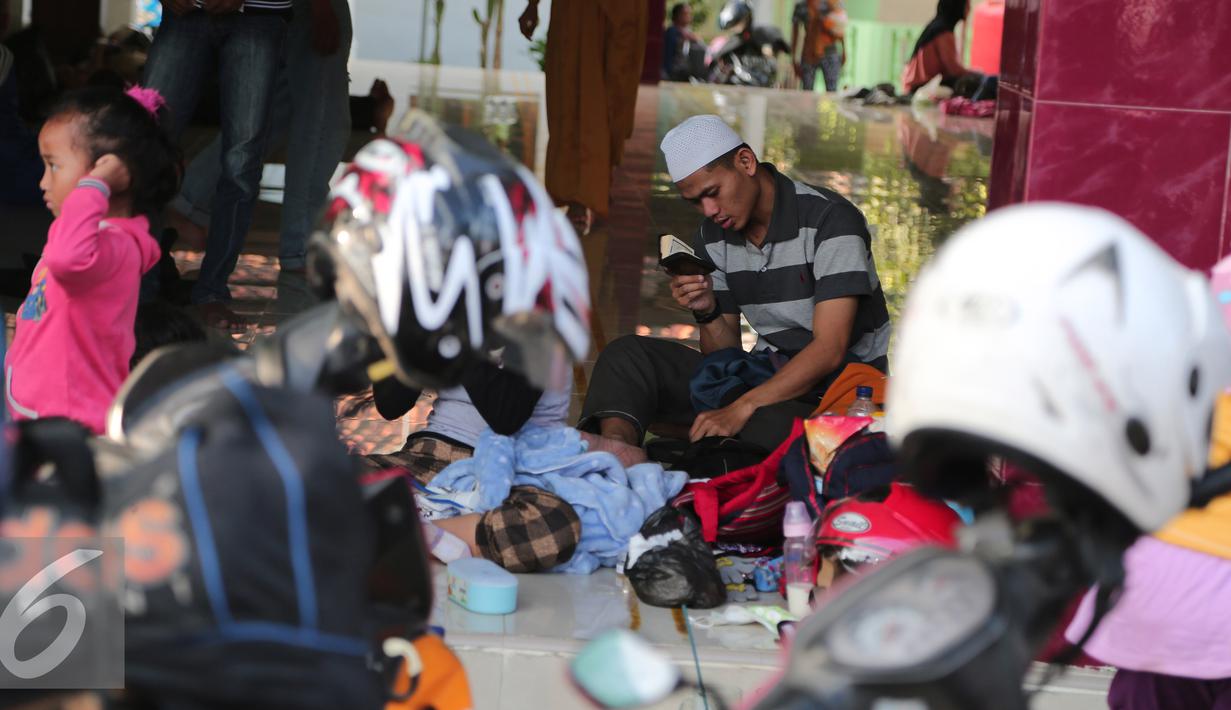 Seorang pemudik terlihat sedang mengaji di sebuah mesjid di kawasan Arjawinangun, Cirebon, Jawa Barat, Rabu (15/7/2015). Banyak pemudik melakukan aktivitas seperti salat, mengaji, tidur dll di mesjid tersebut. (Liputan6.com/Herman Zakharia)