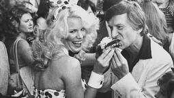 Model Playboy Bunny Betsy menyuapi Hugh Hefner sebuah kue di Hollywood walk of fame, Los Angeles, California, pada 9 April 1980. Hefner mendirikan majalah dewasa Playboy tahun 1953 dengan foto toples Marilyn Monroe diedisi pertamanya. (AP Photo / Loundy)