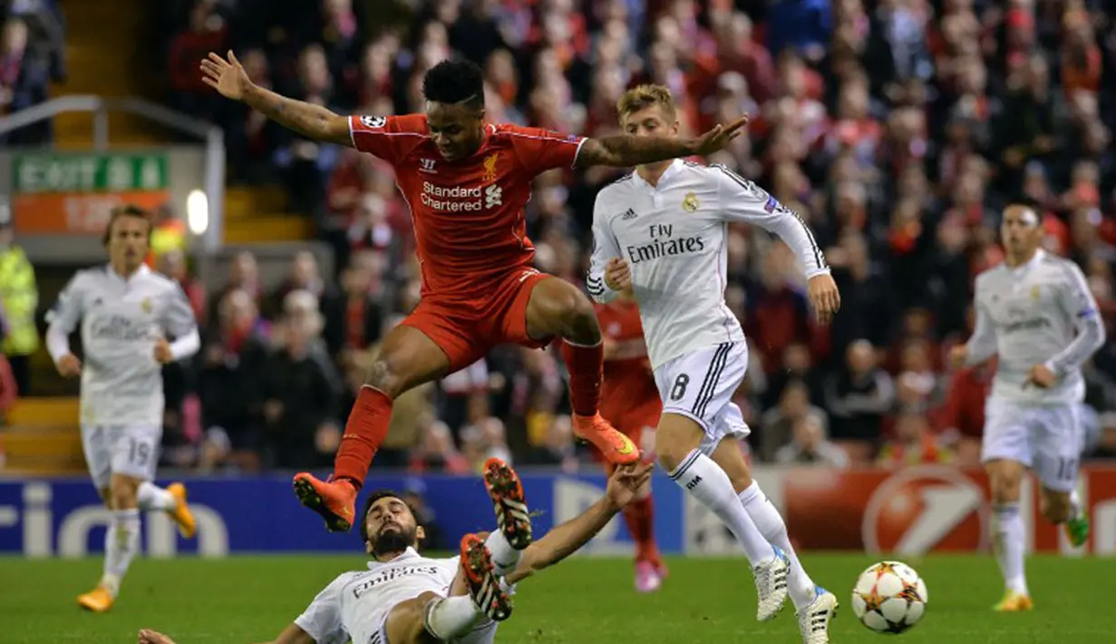 Gelandang Liverpool, Raheem Sterling (atas) melompat menghindari terjangan pemain belakang Real Madrid saat berlaga di Liga Champions Grup B di Stadion Anfield, (23/10/2014). (AFP PHOTO/Paul Ellis)