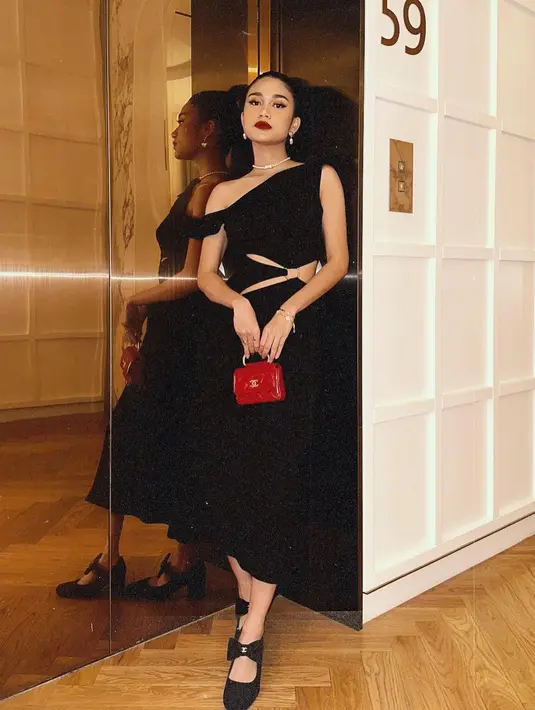 Ia menghadirkan gaya makeup bold dengan area mata yang dipertajam dan pulasan lipstik merah, gaya ikonis Audrey Hepburn. [Foto: Instagram/azizahsalsha_]