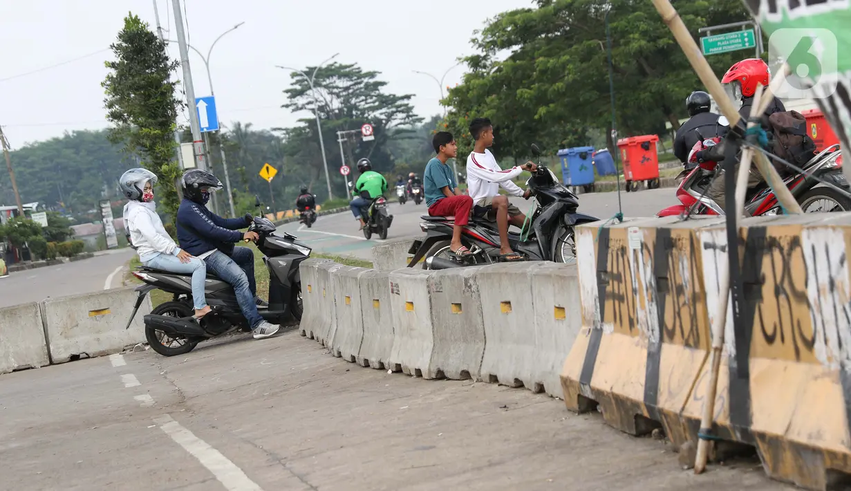 Pengendara motor menerobos beton pembatas di kawasan lingkar Stadion Pakansari, Kabupaten Bogor, Jawa Barat, Rabu (10/6/2020). Hingga Rabu (10/6), Pemkab Bogor masih menutup kawasan Stadion Pakansari untuk semua kegiatan sebagai upaya pencegahan penyebaran COVID-19. (Liputan6.com/Helmi Fithriansyah)