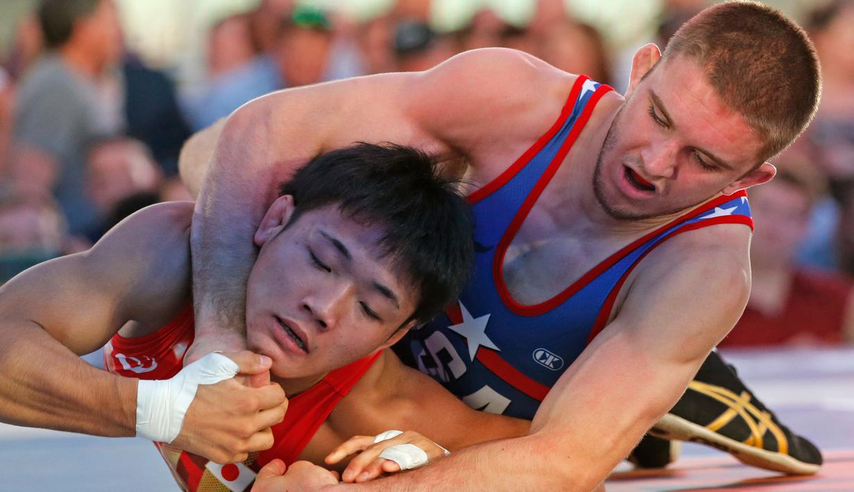 Pegulat AS, Zain Retherford mengunci Daichi Takatani asal Jepang saat pertandingan gulat "Beat the Streets" di New York Times Square, (17/5). Kompetisi gulat ini digelar sebagai program gulat atletik New York. (AP Photo/Kathy Willens)