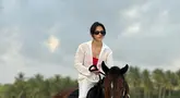 Penampilan Pevita Pearce saat menunggang kuda terlihat kece. Lewat pakaian bernuansa putih, Pevita tampil anggun menunggangi kuda bernama Kayu. (Liputan6.com/IG/@pevpearce)