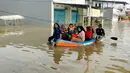 Warga menggunakan perahu karet melintasi banjir yang melanda Perumahan Total Persada, Periuk, Kota Tangerang, Selasa (4/2/2020). Banjir akibat tanggul kali Ledug jebol membuat ratusan rumah di Total Persada terendam banjir hingga mencapai 3,5 meter. (merdeka.com/Arie Basuki)