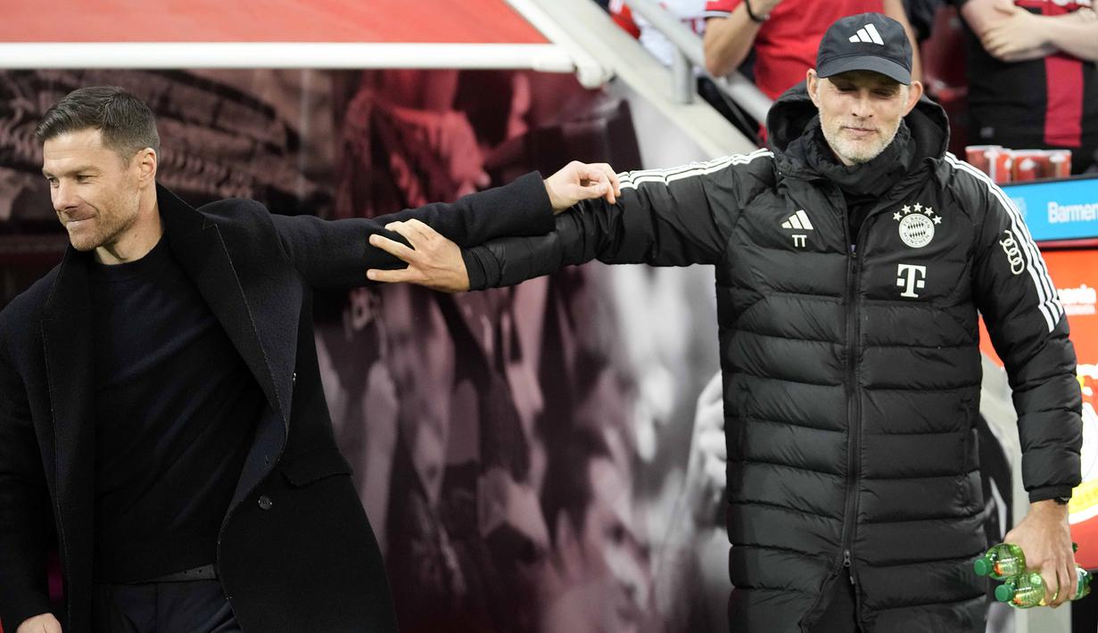 Pelatih Bayer Leverkusen, Xabi Alonso (kiri) berjalan meninggalkan pelatih Bayern Munchen, Thomas Tuchel sebelum laga lanjutan Bundesliga 2023/2024 di BayArena, Leverkusen, Jerman, Minggu (11/02/2024) WIB. (AP Photo/Martin Meissner)