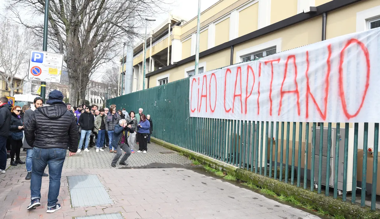 Kain putih bertuliskan 'Sampai Jumpa, Kapten' diikatkan di pagar Stadion Artemio Franchi di Florence, Minggu (4/3). Fans melakukan aksi belasungkawa atas kematian kapten Fiorentina Davide Astori di depan markas klub tersebut. . (Claudio GIOVANNINI/AFP)