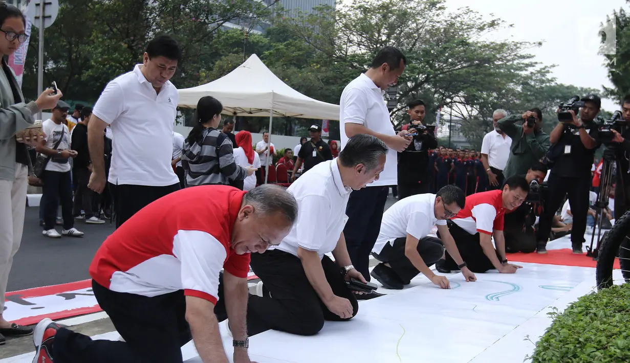 Para pejabat Kemenkumham melukis di atas kanvas sebagai tanda dimulainya lomba melukis massal di depan Kemenkumham, Jakarta, Minggu (13/8). Acara lukis massal ini diselenggarakan secara serentak di seluruh Indonesia. (Liputan6.com/Herman Zakharia)
