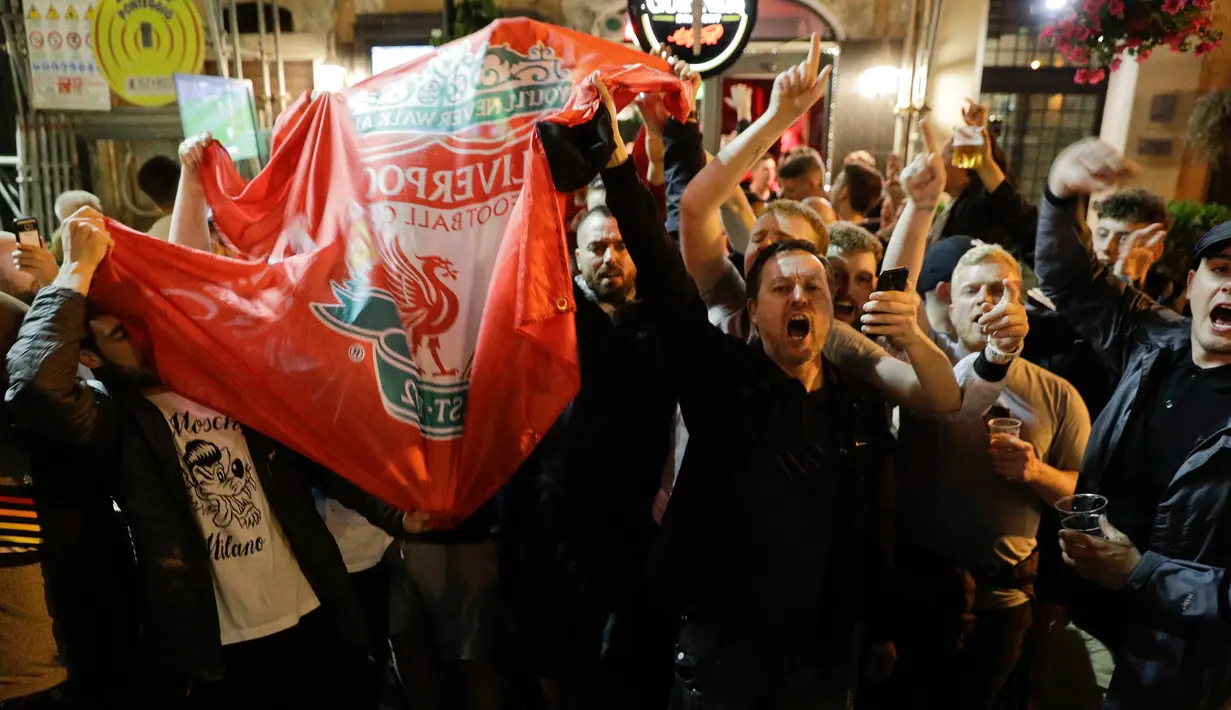 Pendukung Liverpool bernyanyi dan melambai-lambaikan bendera tim mereka di sebuah pub di alun-alun Campo de 'Fiori Roma, Italia (1/5). Liverpool akan menghadapi AS Roma di leg kedua semifinal Liga Champions. (AP Photo/Andrew Medichini )