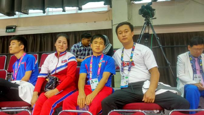 (Foto: Doc. asianparagames2018.id) Pelatih tenis meja Korea Utara, Ri Chol-ung (kanan), berpose dengan salah satu atlet dan stafnya seusai penyerahan medali Asian Para Games 2018.