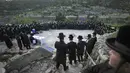 Orang-orang Yahudi Ultra-Ortodoks mendengarkan Rabi Pinsk Karlin selama upacara Maim Shelanu di mata air pegunungan di pinggiran Yerusalem (13/4/2022). Orang Yahudi dilarang makan bahan makanan beragi selama liburan Paskah. (AP Photo/Ariel Schalit)