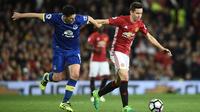 Gelandang Everton, Gareth Barry, berusaha melewati gelandang Manchester United, Ander Herrera. Bermain di kandang Setan Merah tampil menyerang dengan penguasaan bola mencapai 62 persen. (AFP/Oli Scarff)