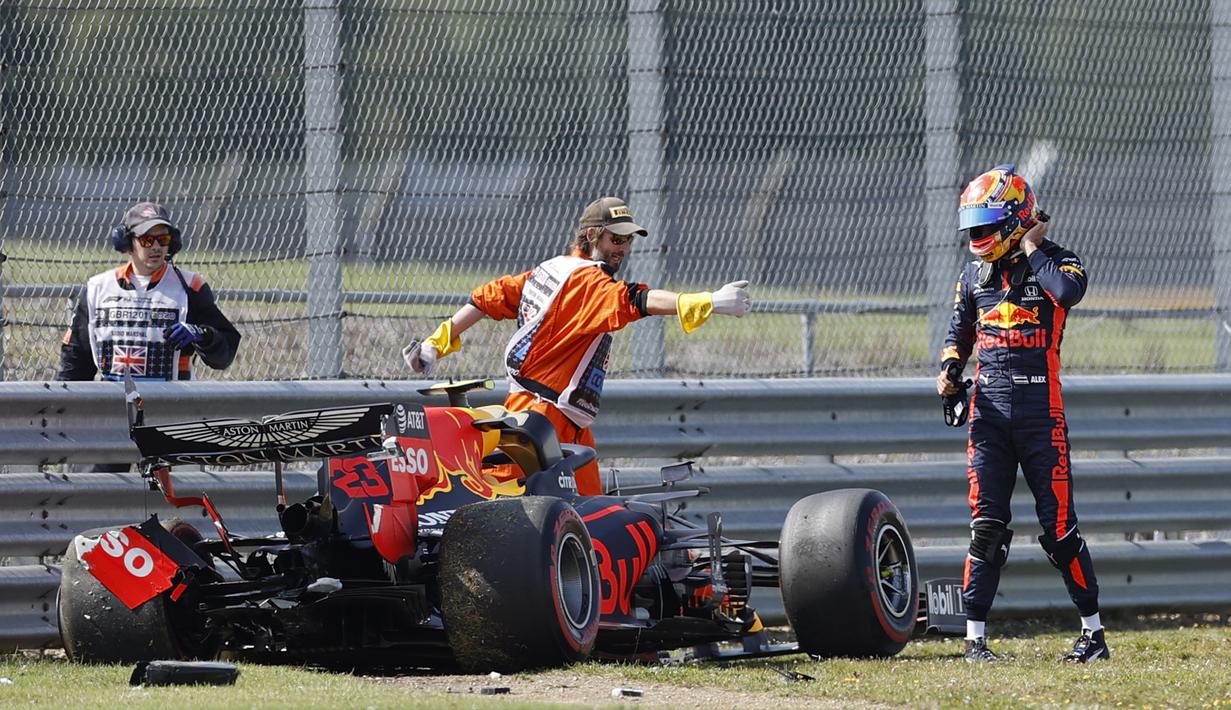 Pembalap Red Bull, Alex Albon, keluar dari mobil usai menabrak pembatas dalam sesi latihan kedua F1 Grand Prix Inggris di sirkuit Silverstone, Inggris, Sabtu (1/8/2020). Albon menempati urutan kedua dengan catatan waktu satu menit 27,364 detik. (AFP/Andrew Boyers/pool)