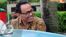 Kasmin hanya menebar senyum ketika meninggalkan gedung KPK, Jumat (11/4/2014) (Liputan6.com/Faisal R Syam).