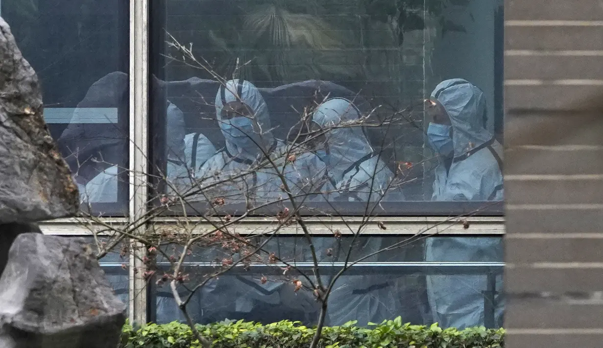Anggota tim WHO mengenakan APD selama kunjungan lapangan ke Pusat Pengendalian dan Pencegahan Penyakit Hewan Hubei di Wuhan di provinsi Hubei,  China  (2/2/2021). Sebelumnya, tim WHO yang beranggotakan 10 pakar telah berkunjung ke pasar, rumah sakit, dan pameran. (AP Photo/ Ng Han Guan)