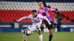 Striker OGC Nice, Alexis Claude-Maurice (kiri) berebut bola dengan gelandang Paris Saint-Germain, Leandro Paredes dalam laga lanjutan Liga Prancis 2020/21 pekan ke-25 di Parc des Princes Stadium, Paris, Sabtu (13/2/2021). Nice kalah 1-2 dari Paris Saint-Germain. (AFP/Franck Fife)