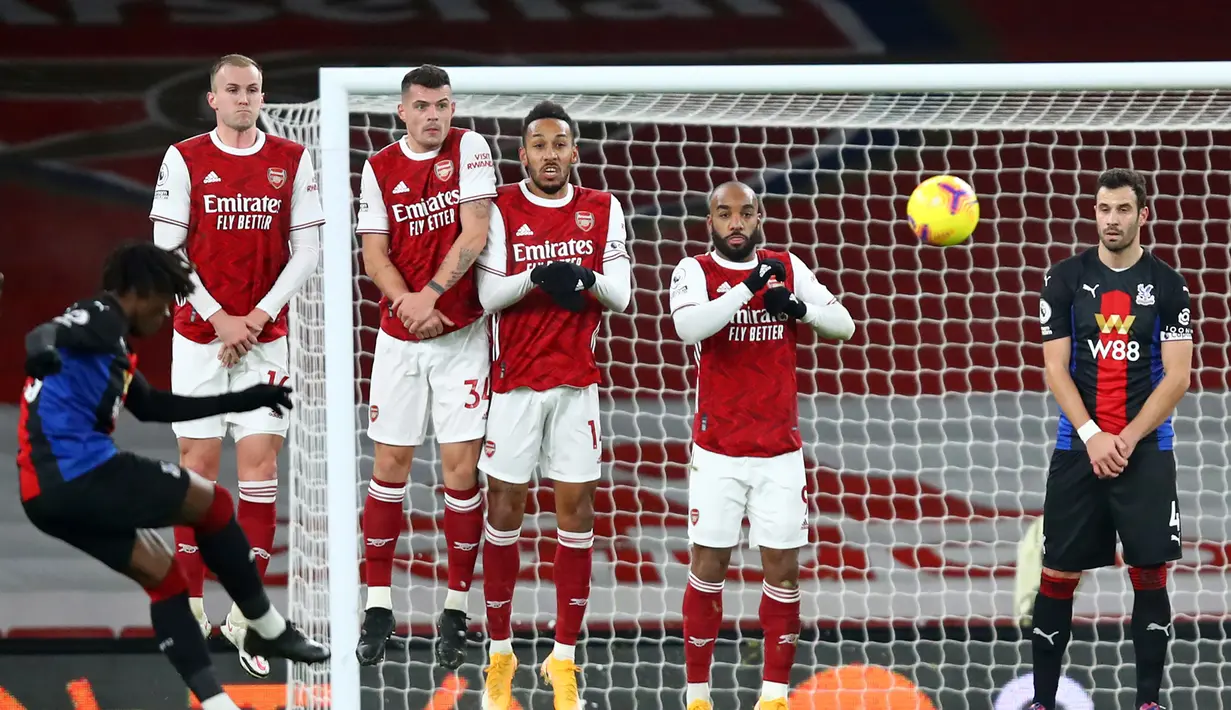 Gelandang Crystal Palace, Eberechi Eze (kiri) melepaskan tendangan bebas ke gawang Arsenal dalam laga lanjutan Liga Inggris 2020/21 di Emirates Stadium, Kamis (14/1/2021). Crystal Palace bermain imbang 0-0 dengan Arsenal. (AFP/Julian Finney/Pool)