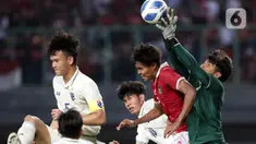 Pemain belakang Timnas Indonesia U-19, Ahmad Rusadi (kedua kanan) berebut bola atas dengan penjaga gawang Thailand U-19, Narongsak Naengwongsa pada lanjutan penyisihan grup A Piala AFF U-19 2022 di Stadion Patriot Candrabhaga, Bekasi, Jawa Barat, Rabu (6/7/2022). Laga kedua tim berlangsung imbang 0-0. (Liputan6.com/Helmi Fithriansyah)