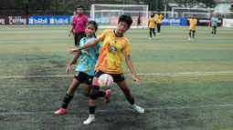 Pemain SDN Kalisari 01, Clea Abelia (kanan) berebut bola dengan pemain SDN Mekarjaya 12, Syakira Olevia dalam laga final MilkLife Soccer Challange Jakarta 2025 kelompok umur 12 tahun di Kingkong Soccer Arena, Cijantung, Jakarta Timur pada Minggu (04/05/2025). (Bola.com/Bagaskara Lazuardi)