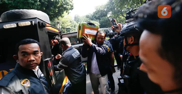 Petugas kepolisian memasukkan barang bukti hasil penggeledahan dari rumah di Sentul terkait dugaan kasus korupsi ke dalam gedung Direktorat Reserse Kriminal Khusus (Disreskrimsus) Polda Metro Jaya, Kamis (9/7/2026), (KLY/Budy Santoso)