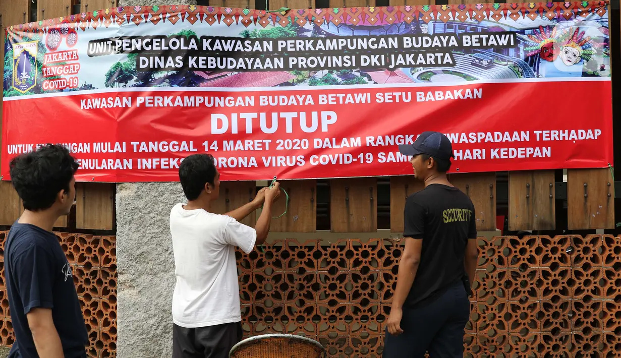 Petugas pengelola memasang spanduk pemberitahuan penutupan Kawasan Wisata Perkampungan Budaya Betawi Setu Babakan, Jakarta, Sabtu (14/3/2020). Hal ini menyusul instruksi Gubernur DKI Jakarta yang menutup sejumlah lokasi wisata selama 14 hari kedepan. (Liputan6.com/Helmi Fithriansyah)