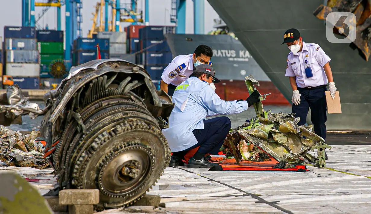 Petugas Komite Nasional Keselamatan Transportasi (KNKT) melakukan identifikasi pesawat Sriwijaya Air SJ 182 di Dermaga JICT, Tanjung Priok, Jakarta, Kamis (21/1/2021). Tim SAR resmi menutup operasi pencarian dan evakuasi korban Sriwijaya Air SJ 182 pada hari ini. (Liputan6.com/Faizal Fanani)