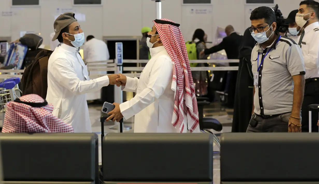 Penumpang saling menyapa saat bersiap terbang dari Bandara Internasional King Abdulaziz, Jeddah, Arab Saudi, Senin (177/5/2021). Warga Saudi yang telah menerima vaksinasi Covid-19 diizinkan bepergian ke luar negeri untuk pertama kalinya sejak Maret 2020. (AP Photo/Amr Nabil)